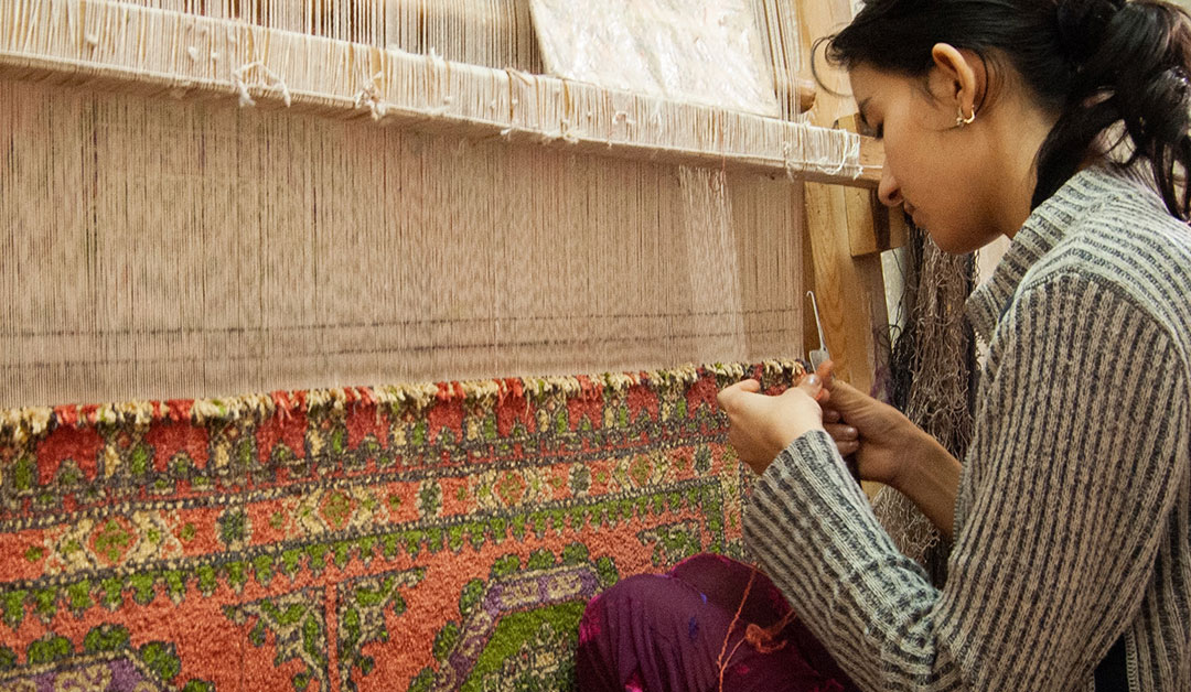Young girl skillfully employing the Handwoven Nepal Rugs Technique on a loom